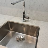 polished and streak free stainless steel sink and tap with stone countertop